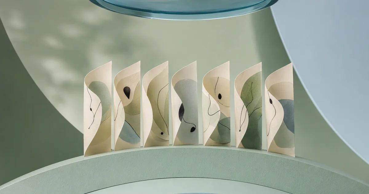 Seven curved ivory paper panels stand along a mint arc, with an overhead blue glass lens revealing their layered structure.