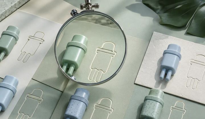 Several distinct mint and pale blue plug-like sculptures beside matching ivory outlines, with one pair aligned under a clear inspection lens