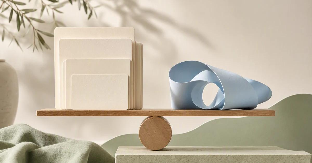 A stack of still-image cards and a loose film ribbon rest beside a balanced wooden pivot.