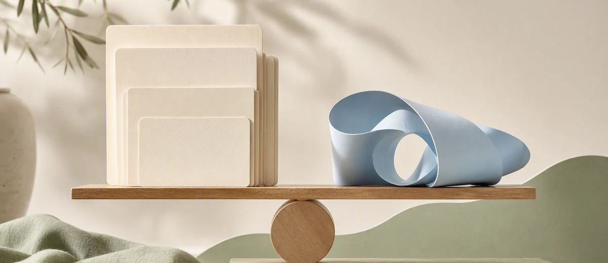 A stack of still-image cards and a loose film ribbon rest beside a balanced wooden pivot.