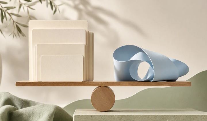 A stack of still-image cards and a loose film ribbon rest beside a balanced wooden pivot.