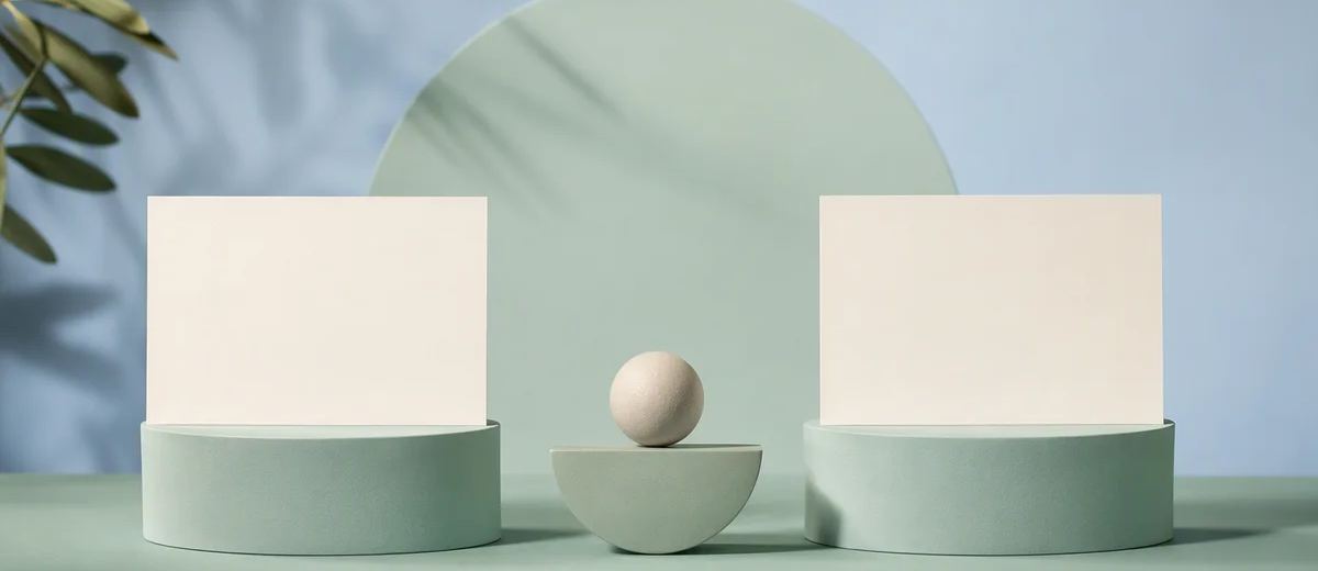 Two unmarked ivory editorial cards on equal mint pedestals under balanced pale blue studio lighting, with a small central balance form