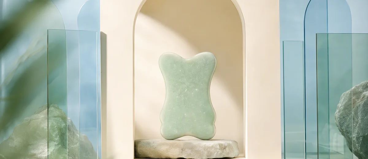 A rounded mint sculpture rests on a stone pedestal inside an ivory arch, surrounded by translucent blue panels.