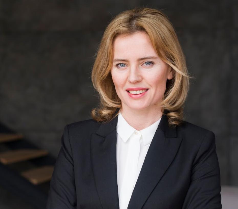 Professional author headshot of a smiling woman in a neutral background