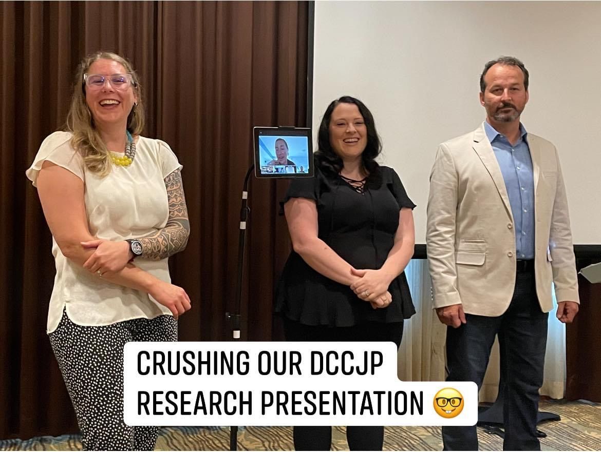 Dr. Elizabeth Hoefer and two colleagues standing together after presenting their DCCJP research findings at a conference.