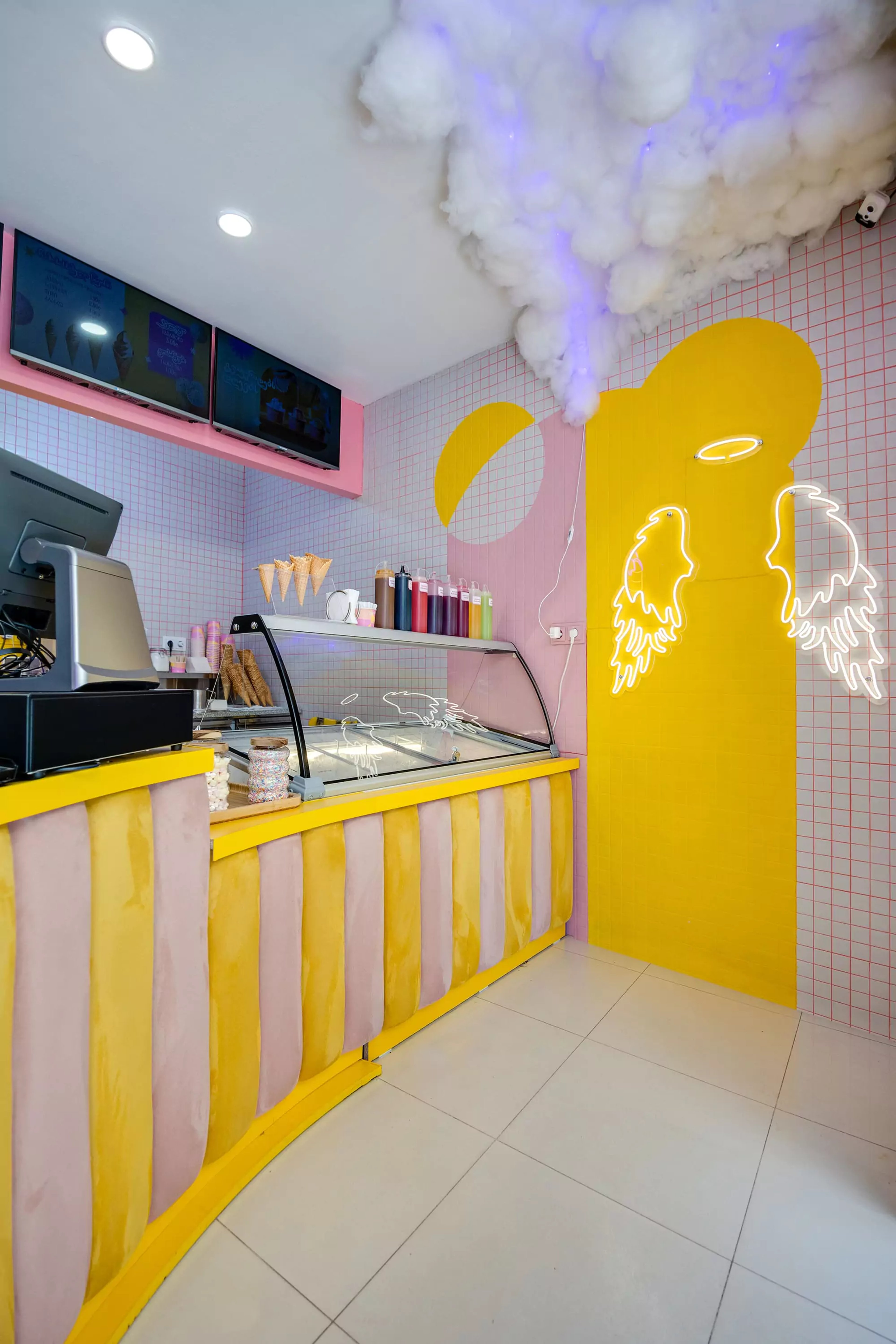 Barambo ice cream counter with neon angel wings and grid tiling