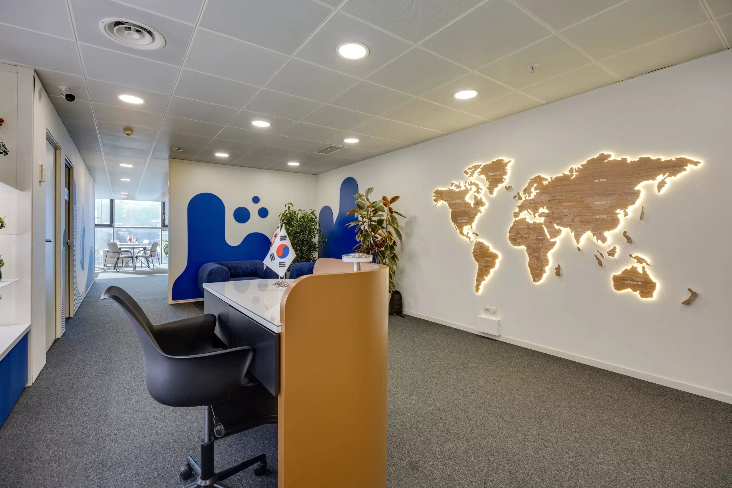 Backlit wooden world map on the KOTRA office wall - a brand-book-based interior accent