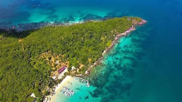 富国岛（Phu Quoc）航拍全景，翠蓝海水环绕茂密绿林，白沙滩清晰可见，是越南最著名的度假岛屿 / Win Royal Spa 皇家越式按摩