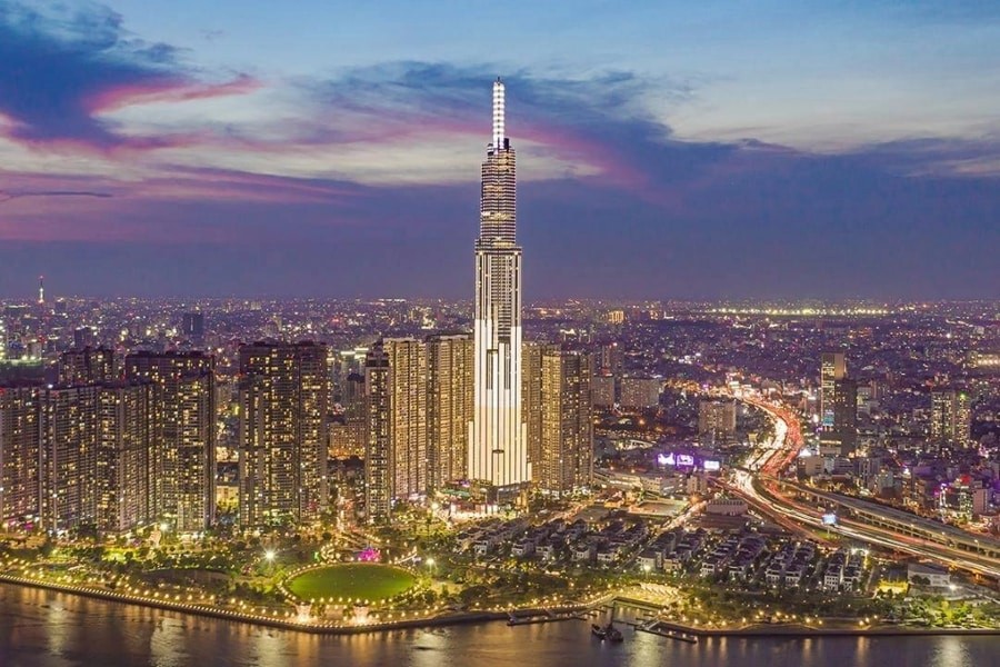 胡志明市夜景鳥瞰，Landmark 81 高聳入雲，西貢河蜿蜒其旁，城市燈火璀璨，盡收眼底