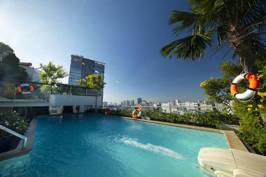 Alagon Saigon Hotel & Spa 天台泳池，棕櫚樹環繞，俯瞰胡志明市第一郡市景，是市區少見的高空泳池