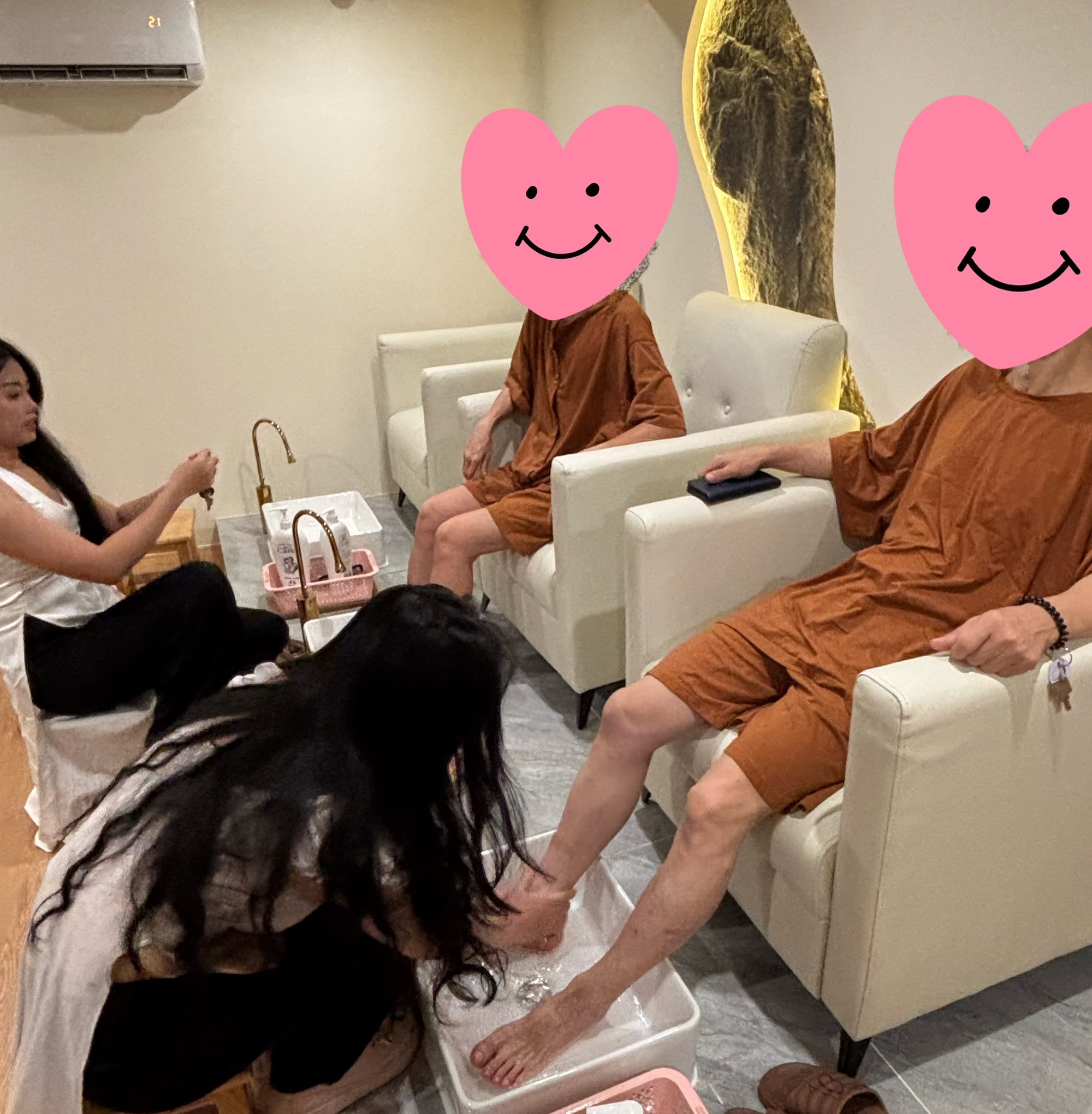 Win Royal Spa 按摩师为客人进行足部清洗服务，客人穿着店内提供的服装