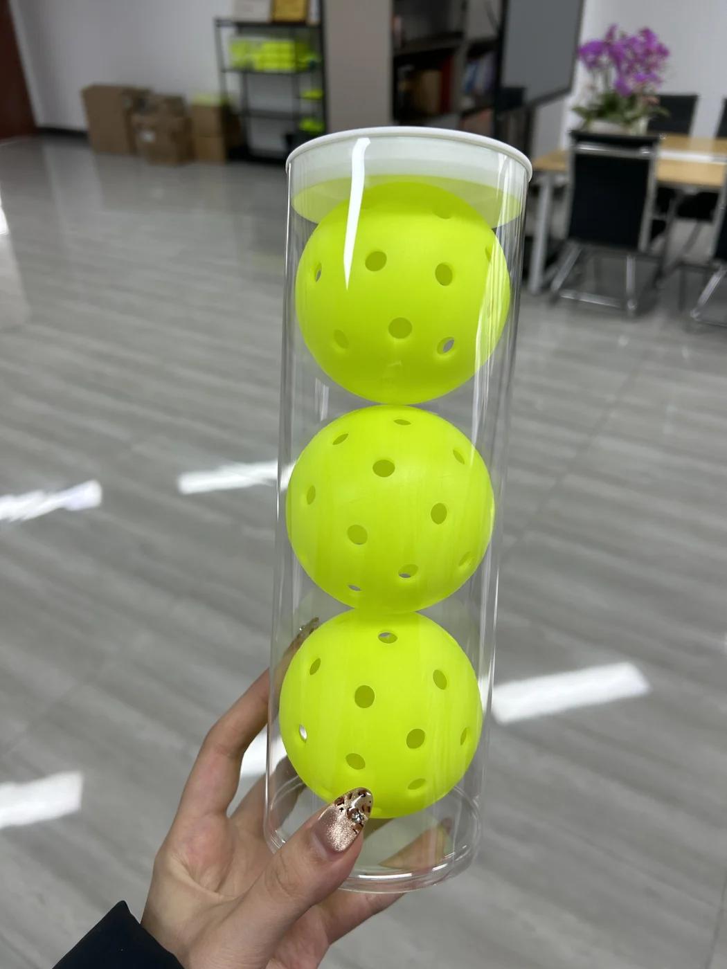 Three yellow balls inside a transparent retail tube