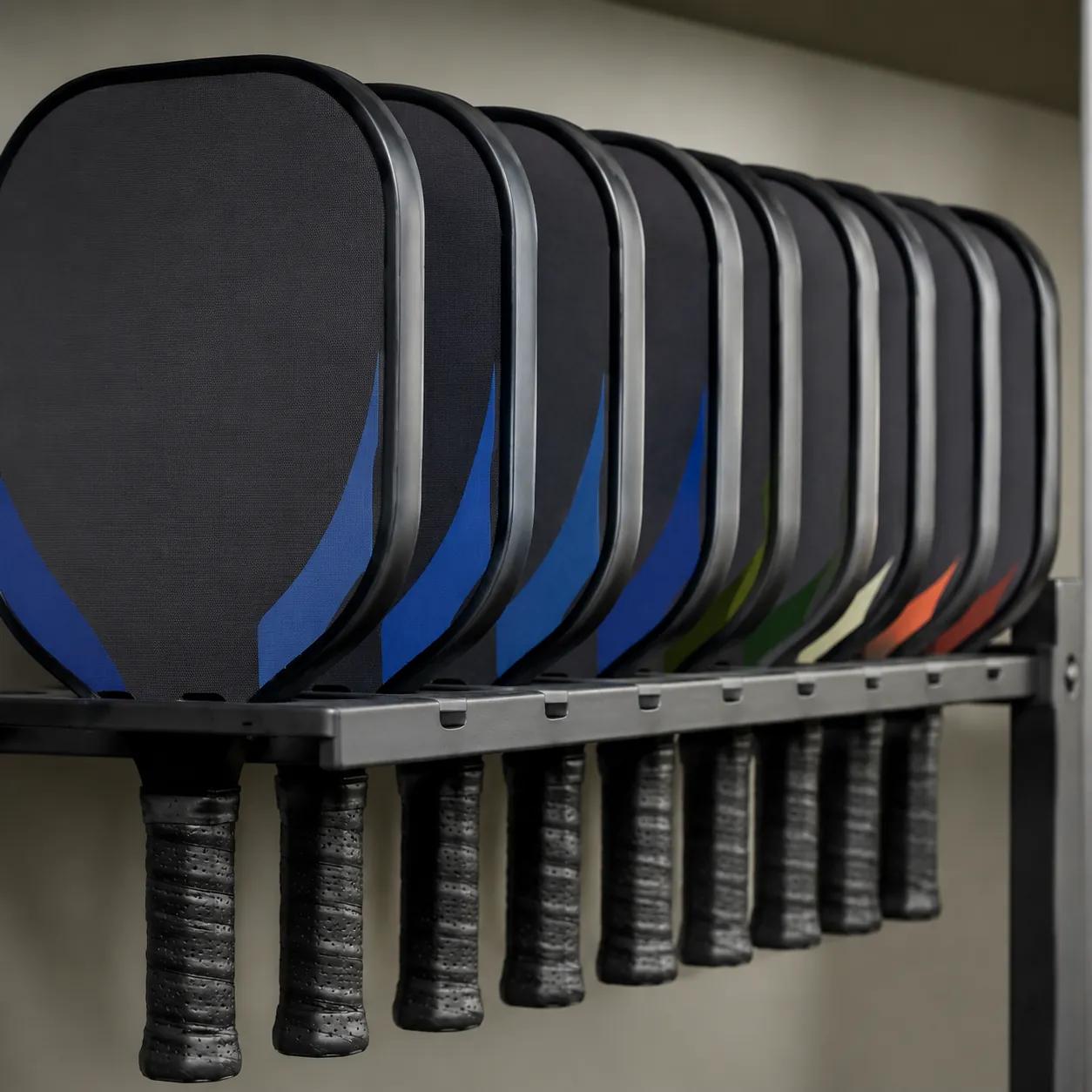 Hyper-realistic product photography, a neatly arranged row of durable pickleball rental paddles in a club storage rack, thick edge guards and textured grips visible, soft diffused studio lighting, shallow depth of field, clean composition, no text, no brand logo