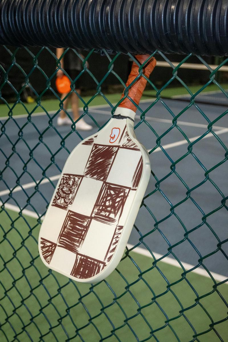 Hyper-realistic product photography, a premium matte black pickleball paddle resting inside a custom fitted foam insert within a sleek minimalist cardboard box, elegant soft box lighting from the left side, luxury unboxing perspective, sophisticated private label presentation, no text, no brand logo