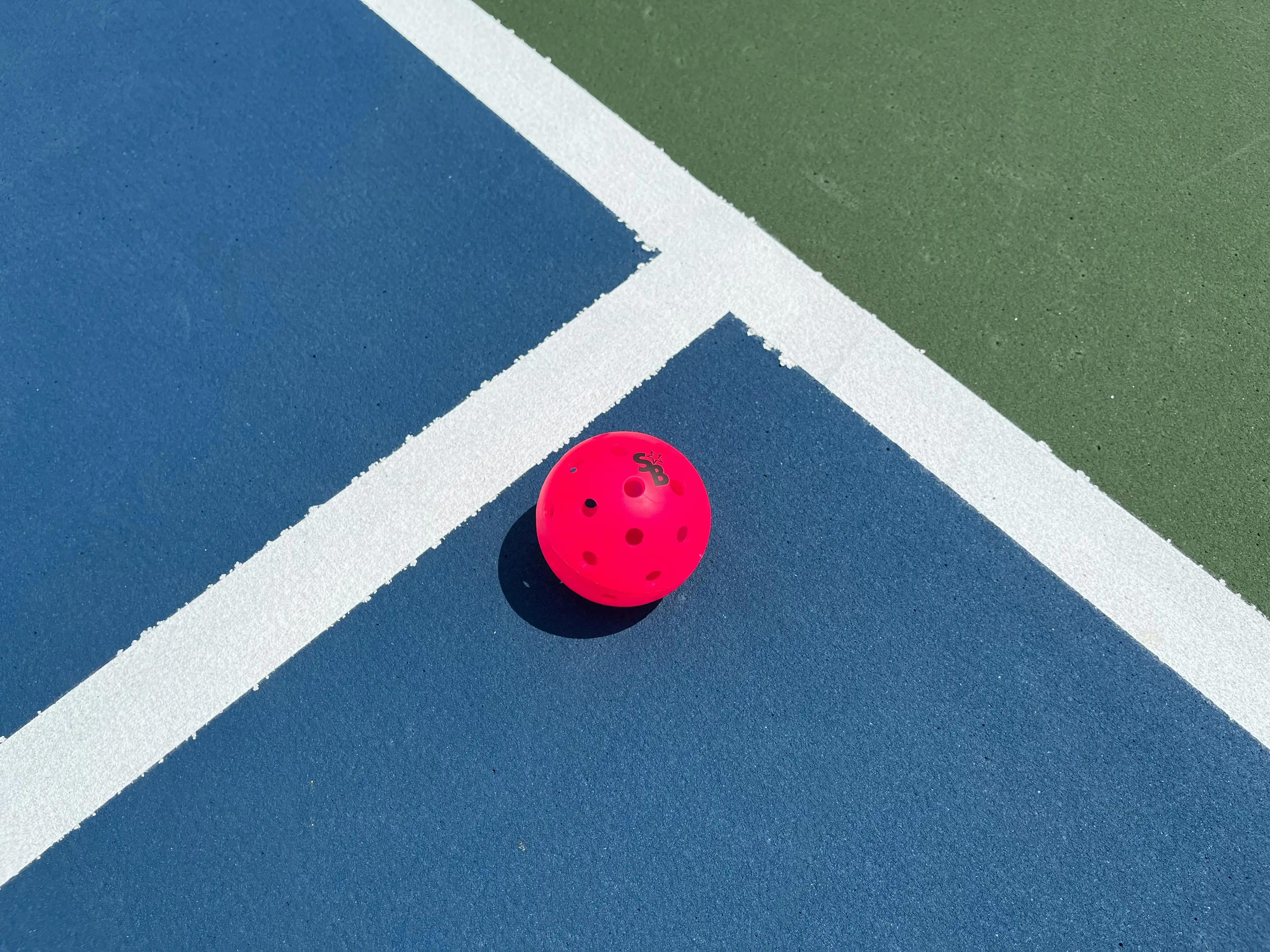 Pickleball paddle being weighed on a digital scale during production quality control, illustrating why a weight row needs a stated tolerance and method