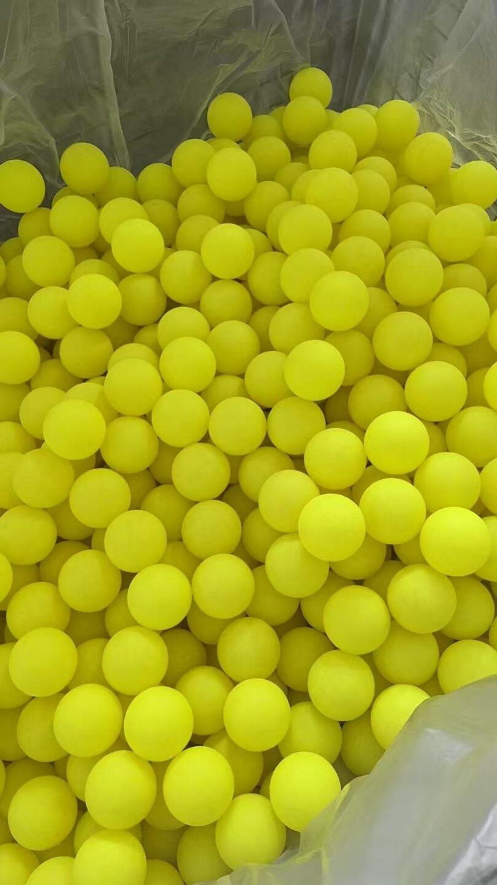 Inspector checking a 40-hole outdoor pickleball for hardness, weight and roundness before packing