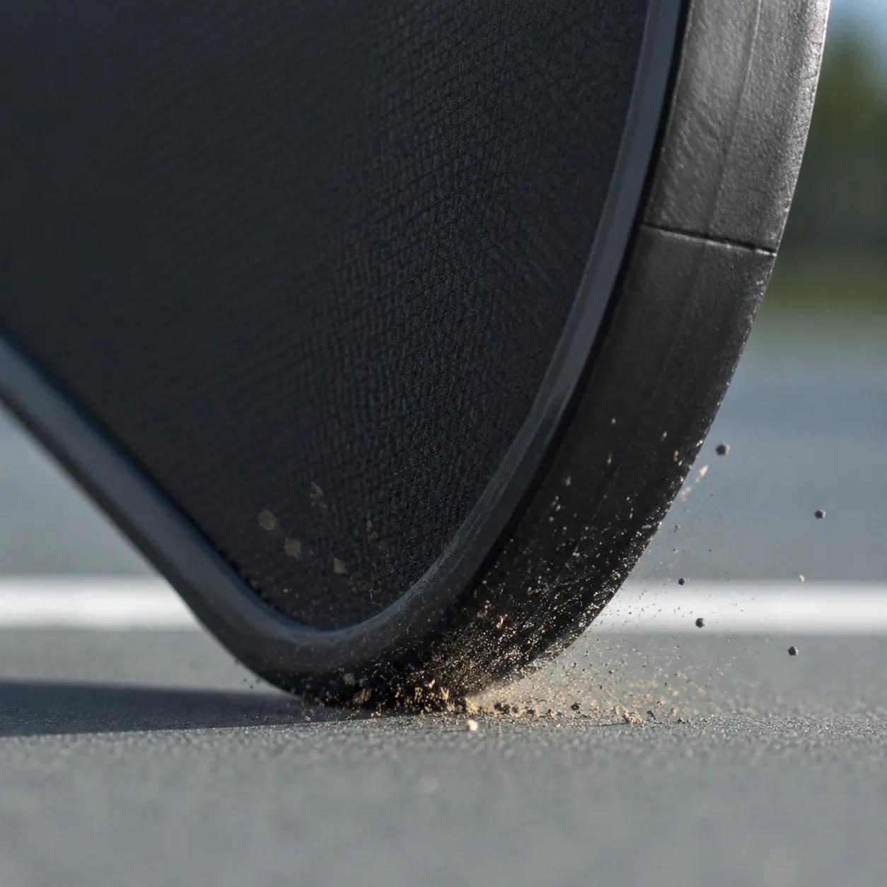 Hyper-realistic product photography, close-up of a pickleball rental paddle edge guard being stressed by a drop impact on a hard court surface, macro detail of the one-piece molded edge absorbing force, dramatic side lighting, no text, no brand logo