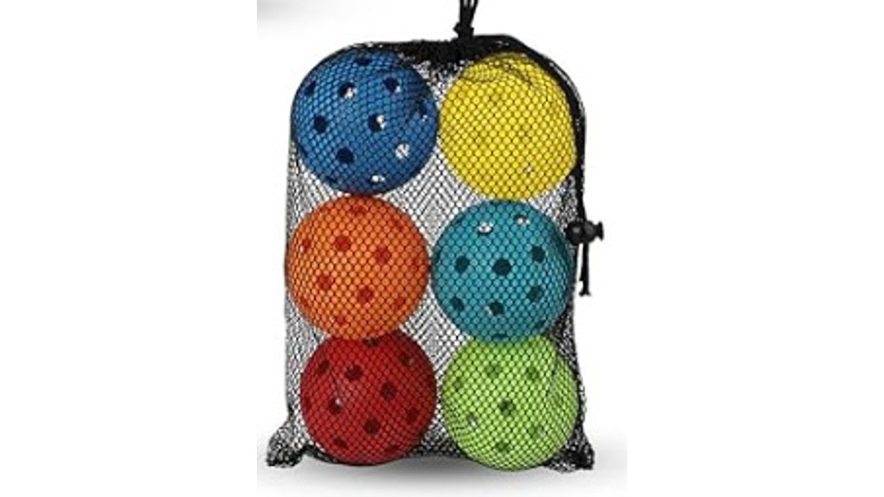 Pickleballs in six bright colours in a mesh carry bag, the kind of bright primary palette the regulation names as a childhood colour association