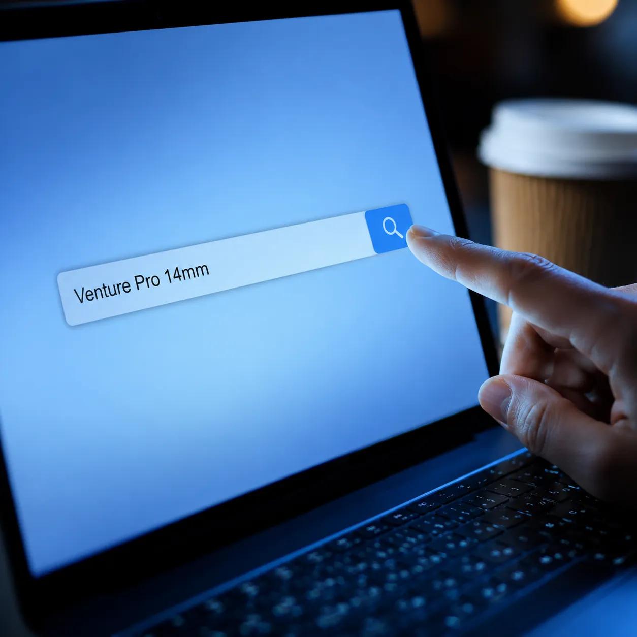 A hand pressing the search button on a laptop screen with a pickleball paddle model name typed into the search field