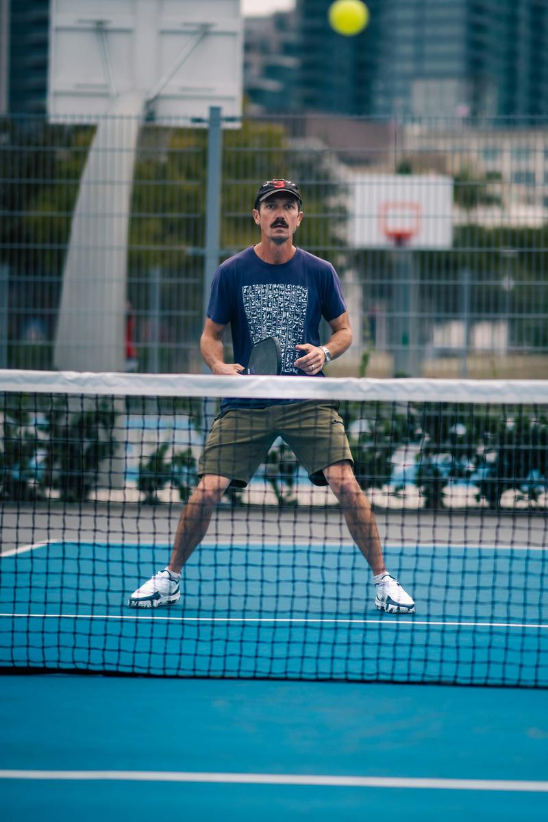 Hyper-realistic product photography, close-up of a pickleball paddle showing edge separation and core crushing defects, placed next to a factory audit clipboard with inspection checklists, industrial factory floor background blurred, dramatic side lighting emphasizing surface imperfections, B2B sourcing context, no text, no brand logo
