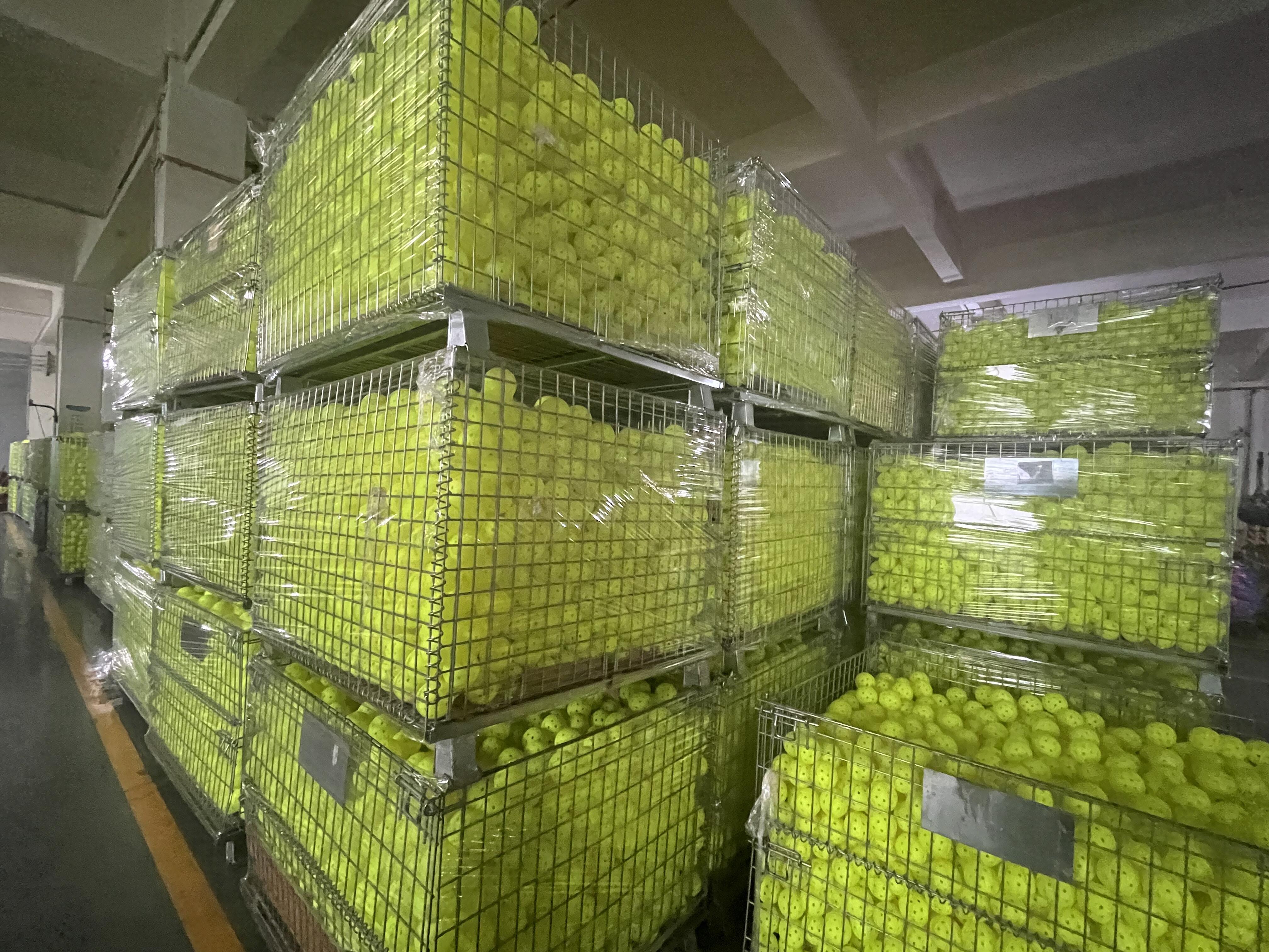 Bulk pickleball stock crated at a source factory, the volume a school or rec program buys at