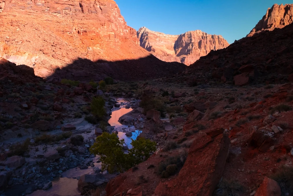 Evening light on distant peaks above the river in the widening canyon