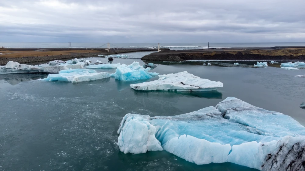 Bright blue icebergs floating in the glacier lagoon on an overcast day
