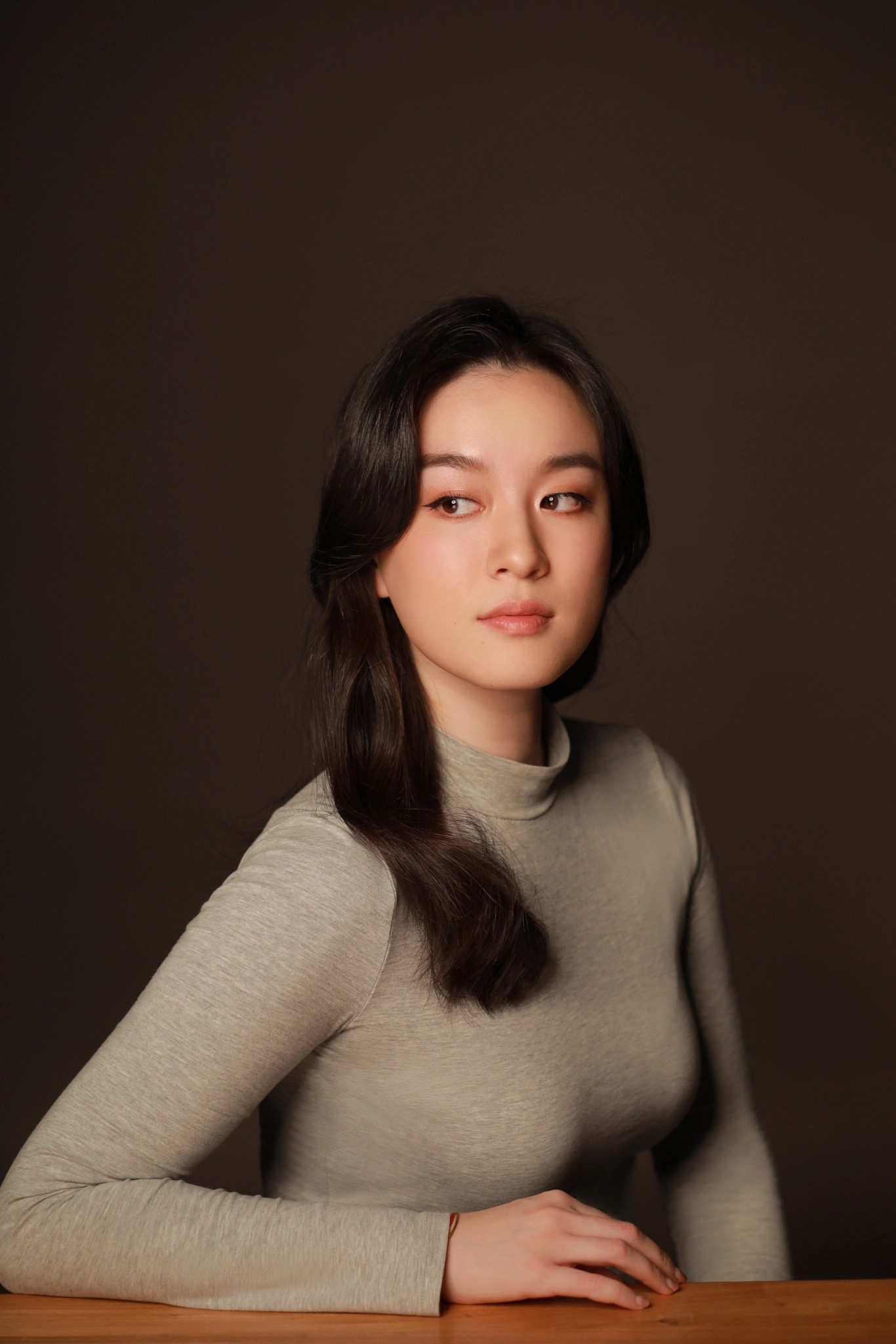 Woman with long black hair gazes to her right