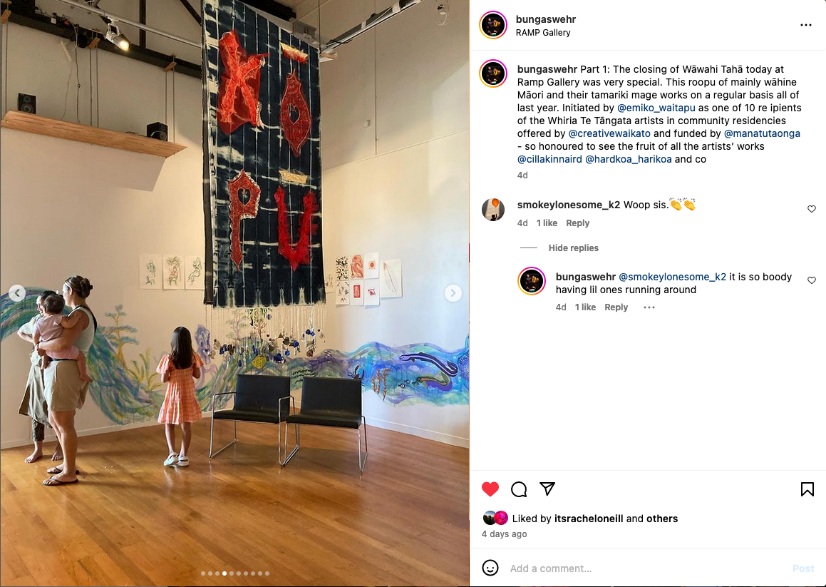 An Instagram post showing a photo of an exhibition with a hanging banner and painted mural, mothers and children in the room