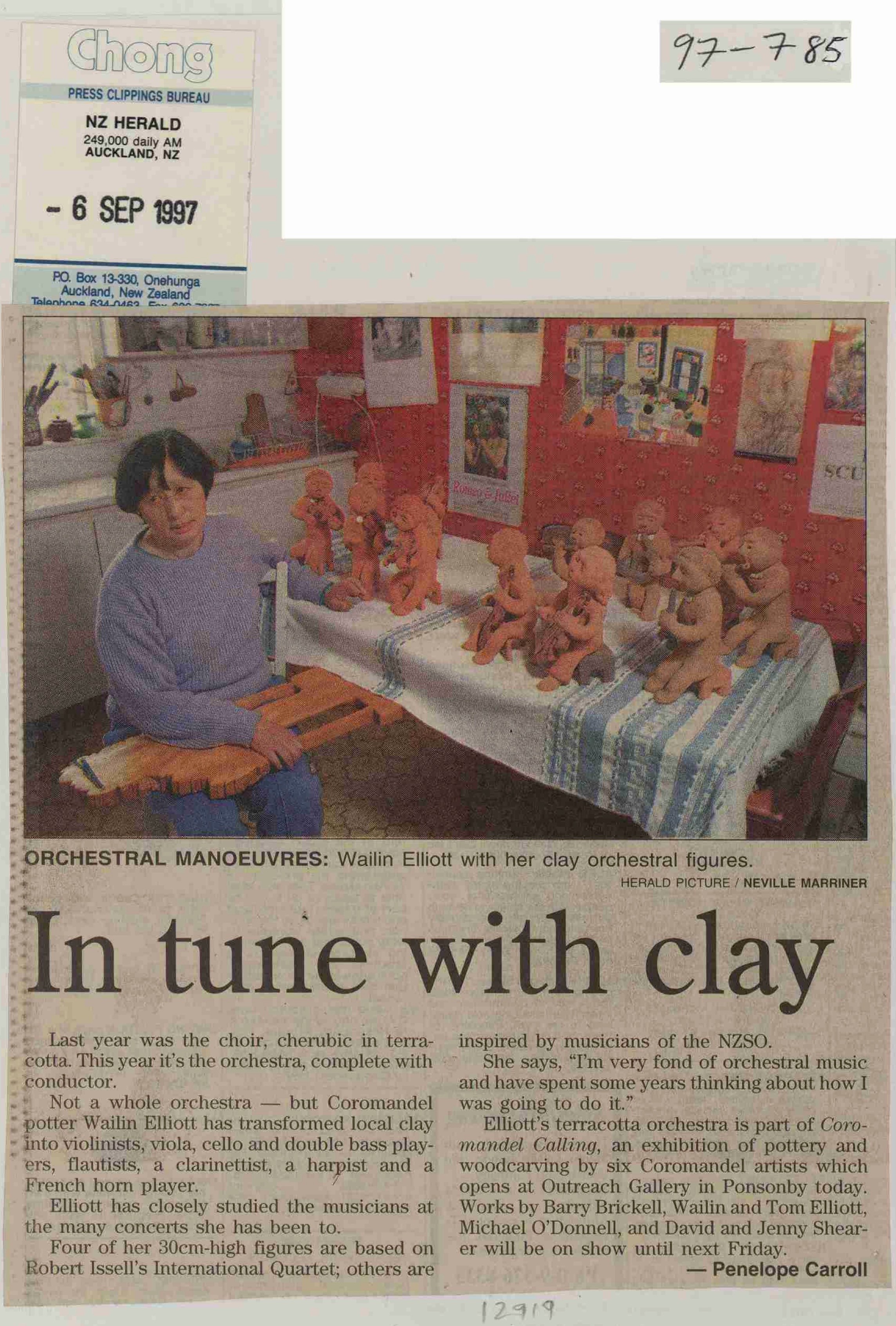 Nespaper clipping with colour photo of Wailin Elliott with her clay figures of musicians.
