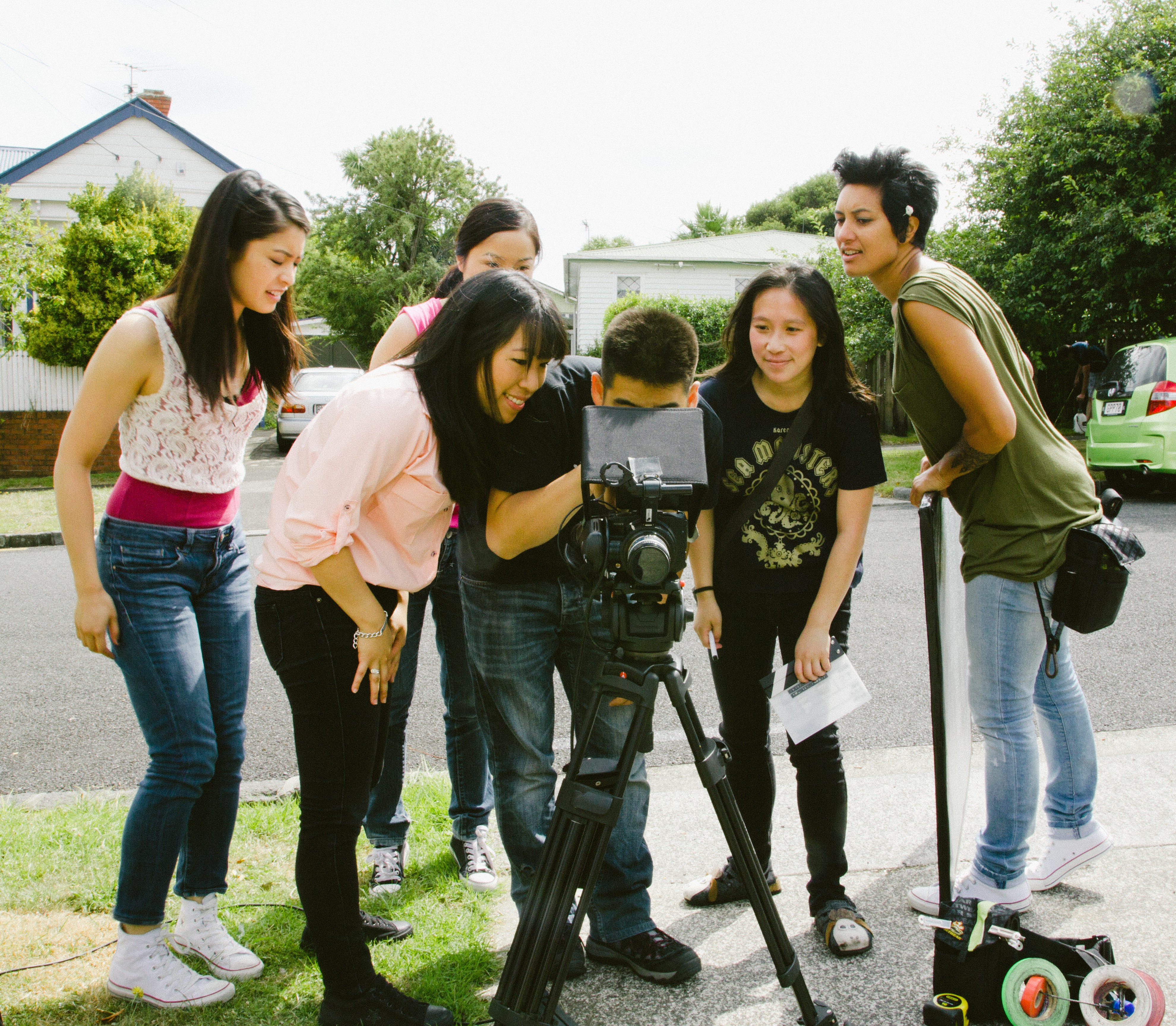 A group of people crowded around a camera