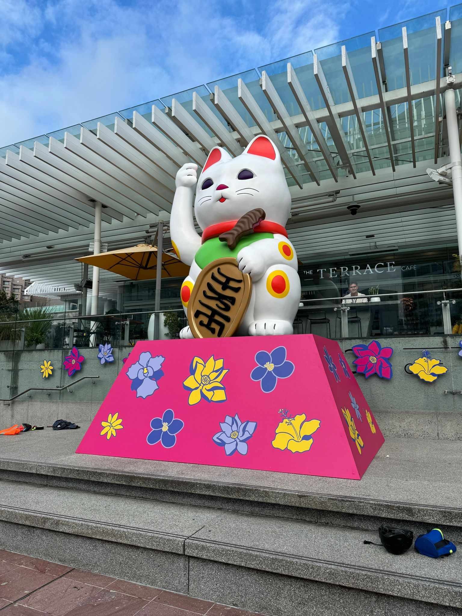 A large Maneki-neko sculpture in front of a building