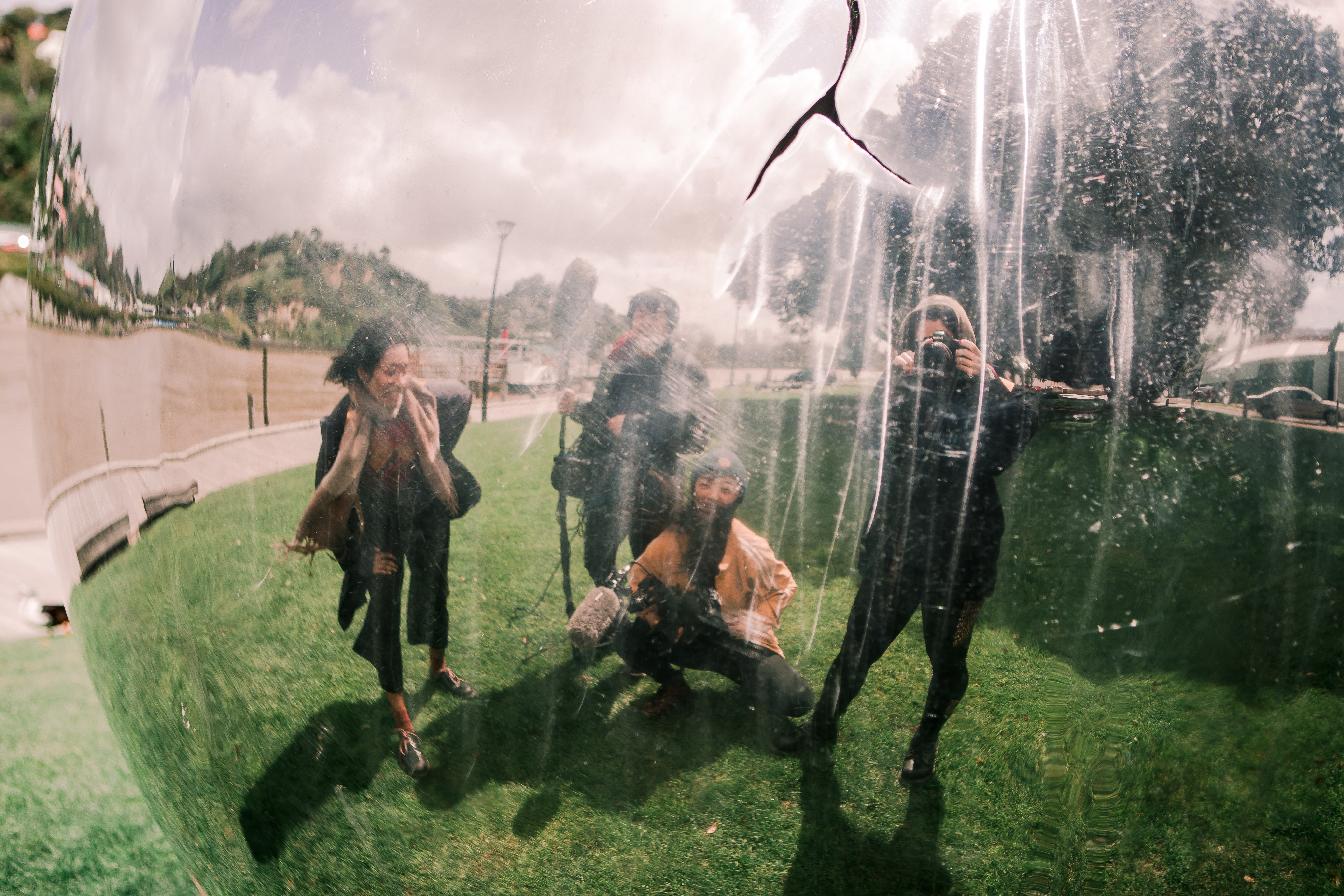 Four camera crew members taking a selfie in a reflective surface