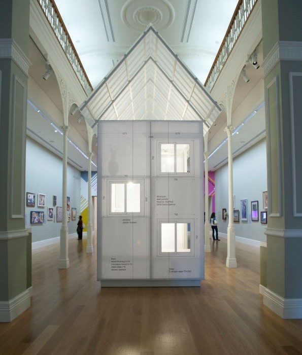 A lifesized model of a small house, made of paper, sits inside Auckland Art Gallery.