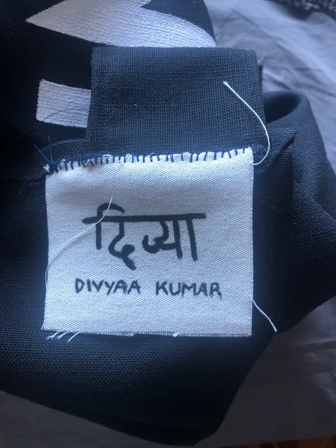 The name 'Divyaa Kumar' written on a fabric clothing tag