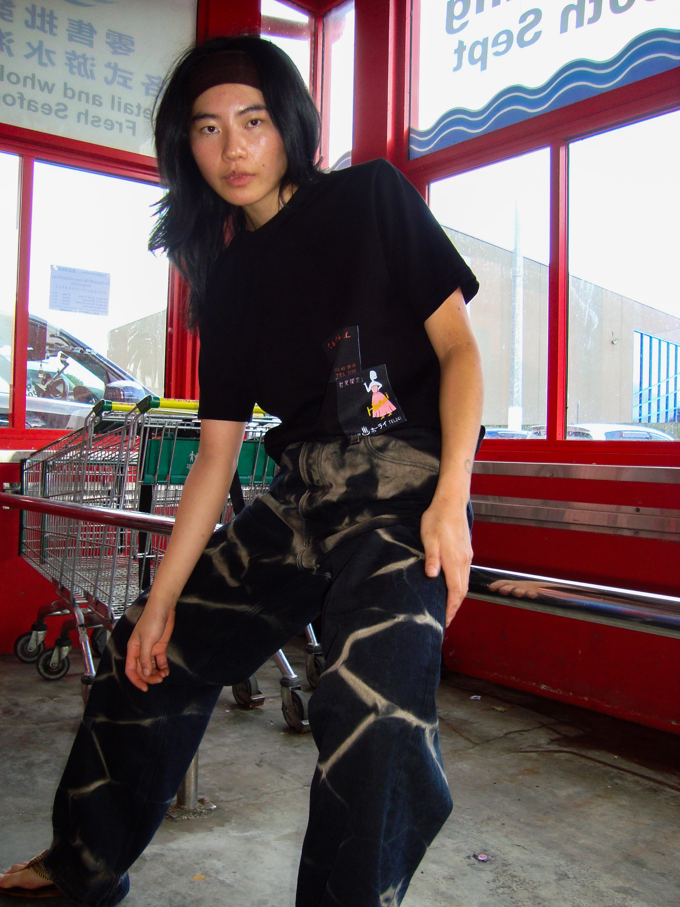 a model posing at an asian supermarket trolley parking area