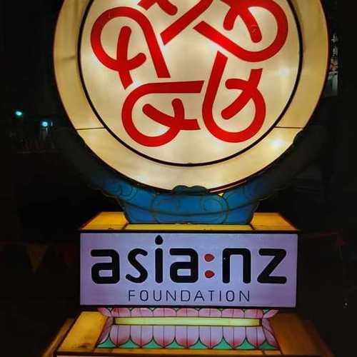 A fabric lantern featuring the Asia NZ Foundation logo is illuminated in the night.