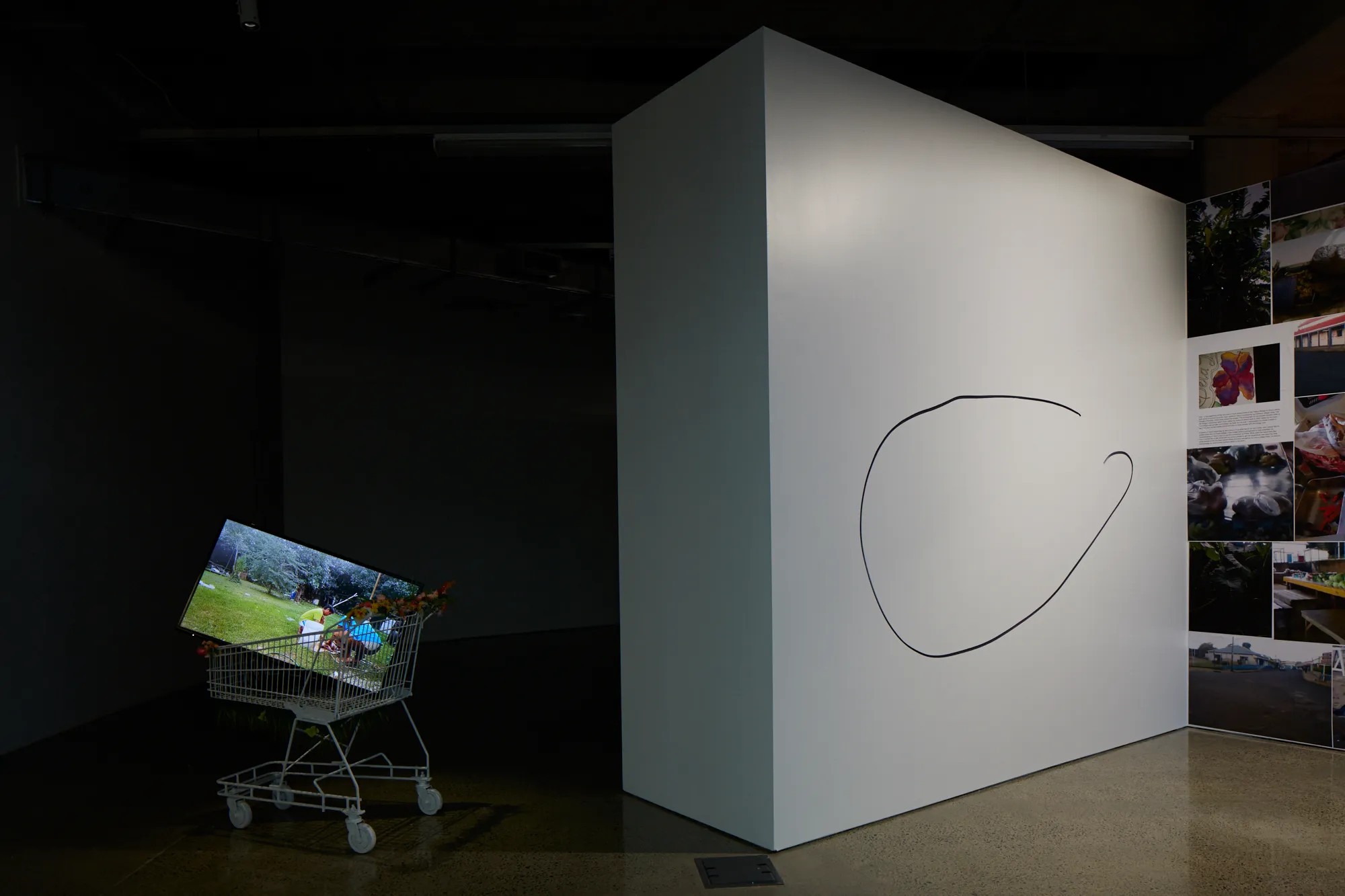 A video screen in a trolley next to a white wall with an incomplete circle drawn on it