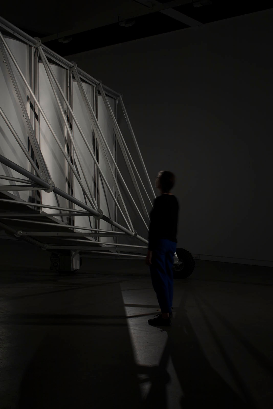 A gallery visitor is dwarfed by a scaffold structure.