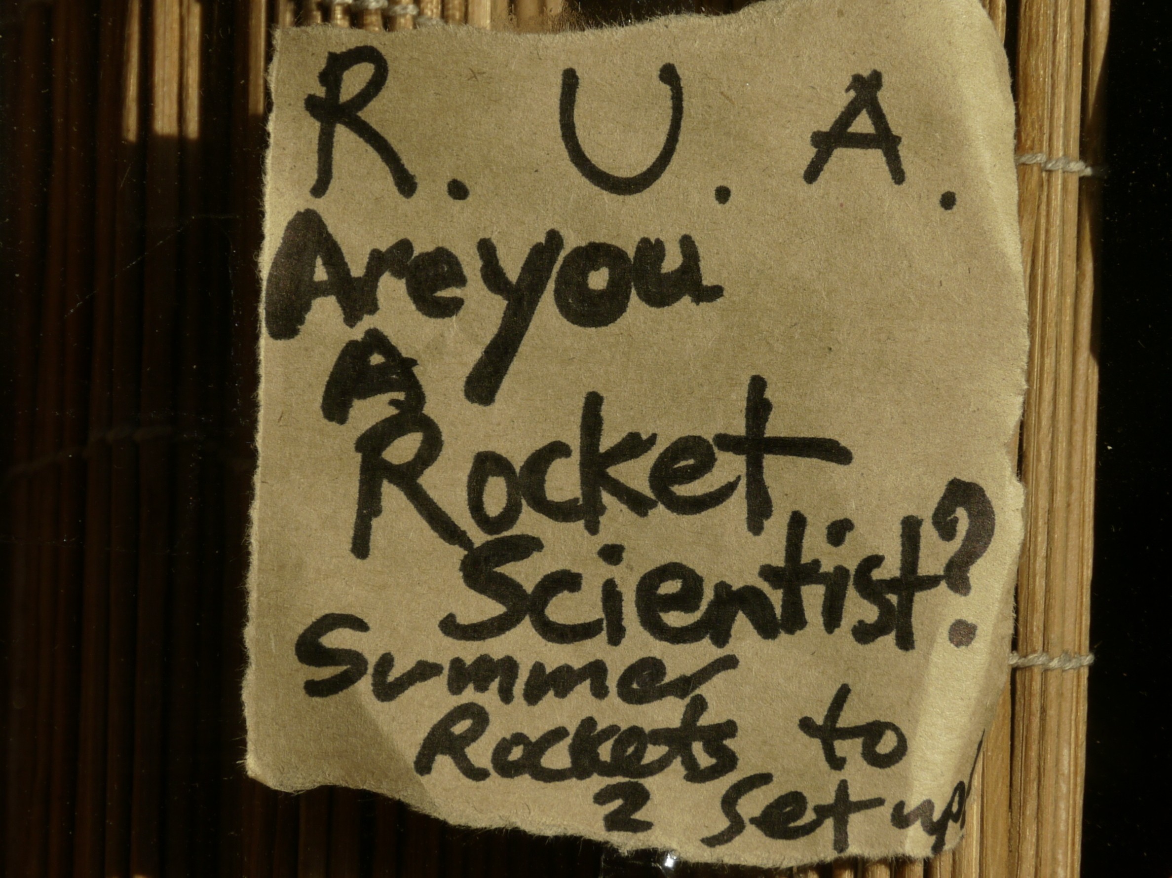 A note on a door that says 'R U A rocket scientist'