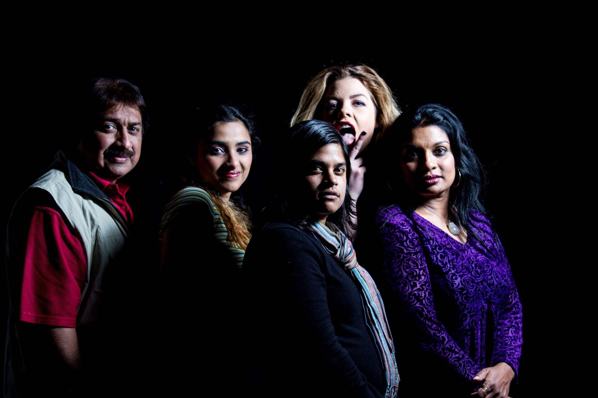 A group of people standing together in front of a black background