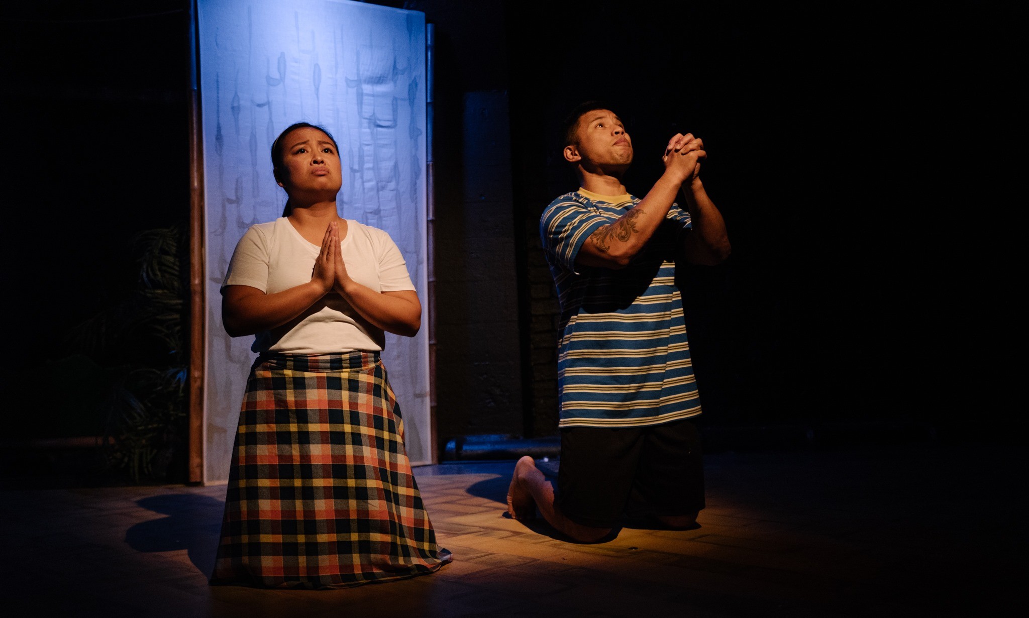 Two people on their knees praying