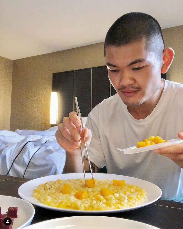 Sam Low places pieces of pumpkin on a bowl of risotto with chopsticks.