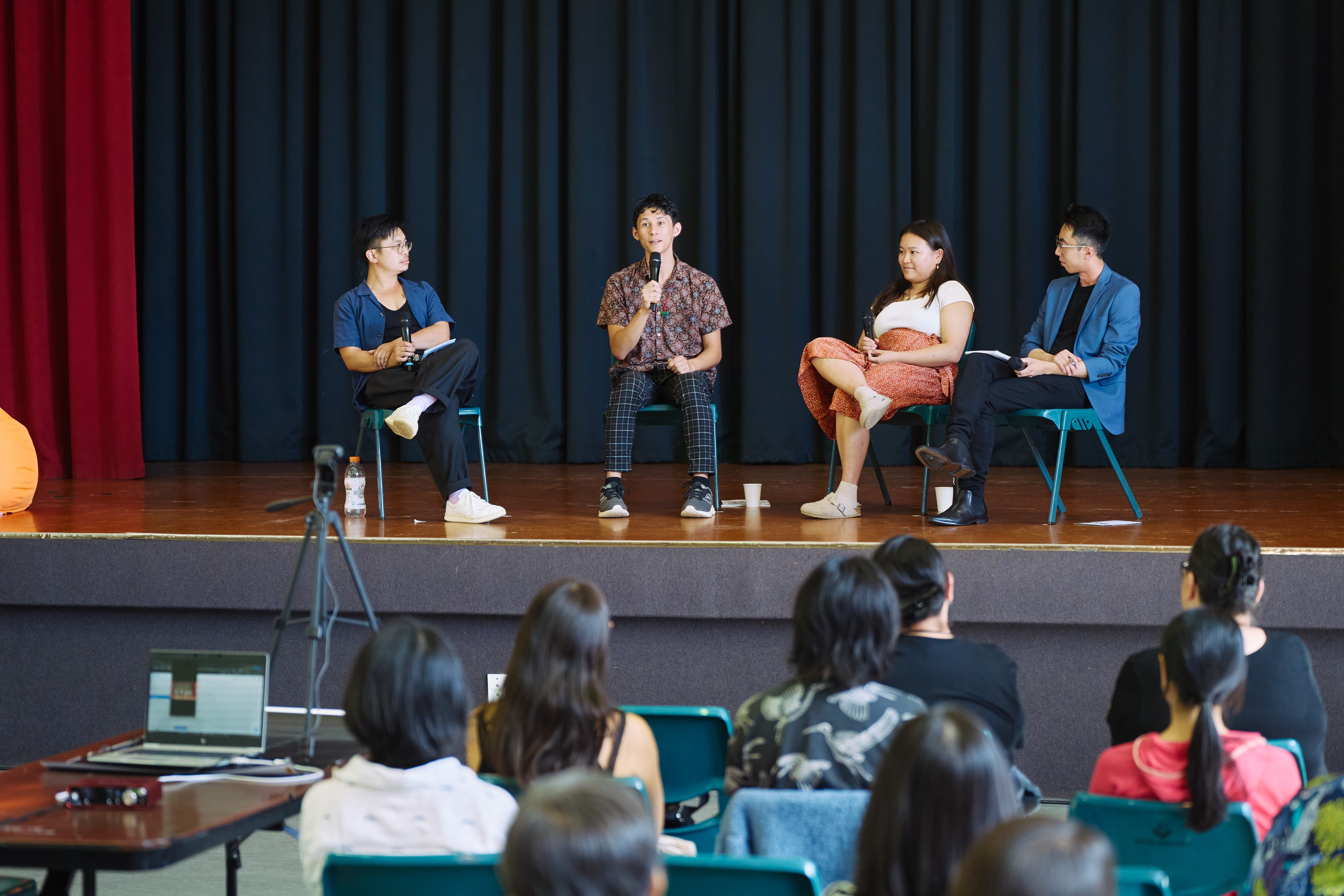 Four people sitting on a stage