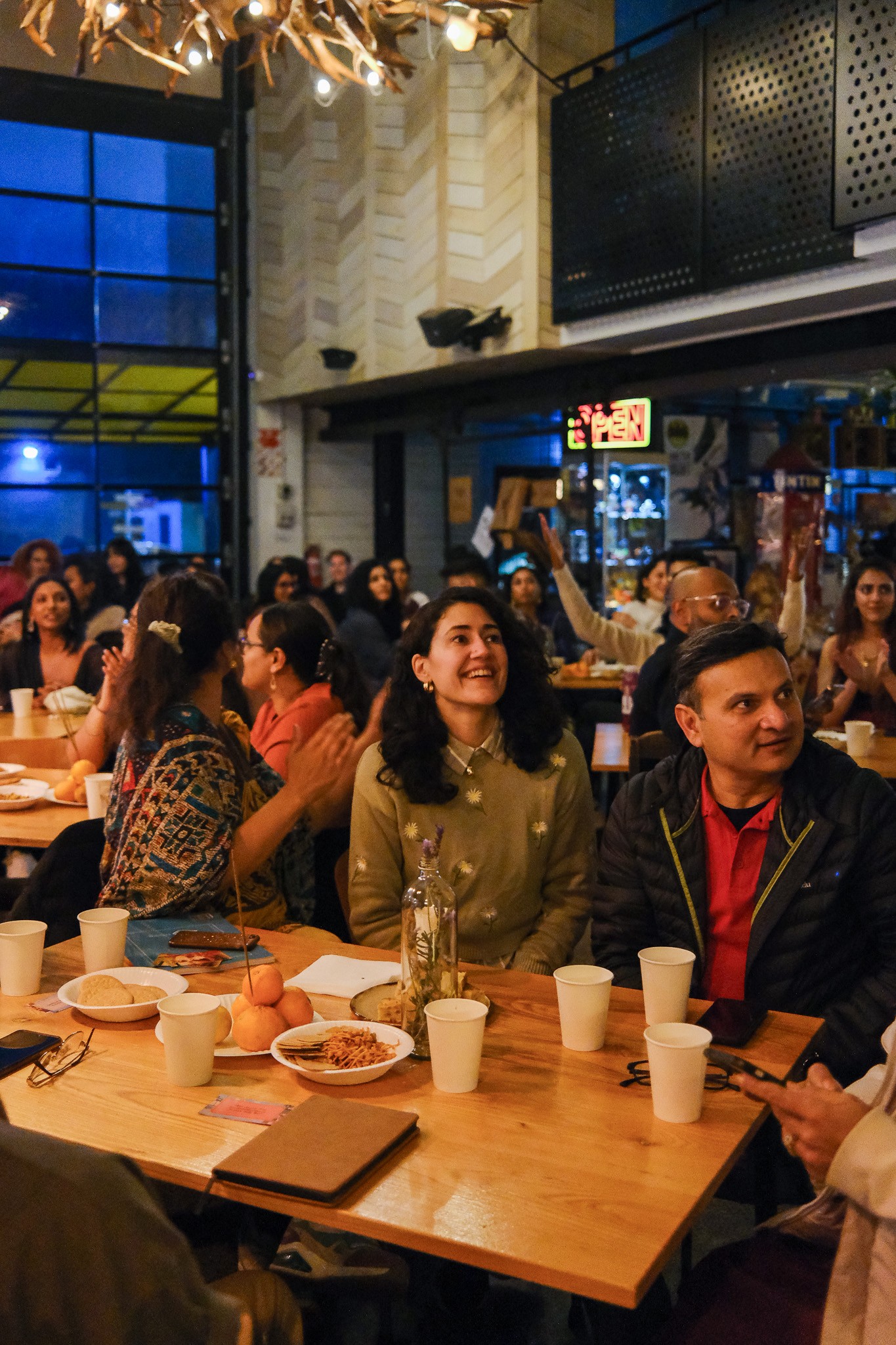 A crowded room with people sitting at tables