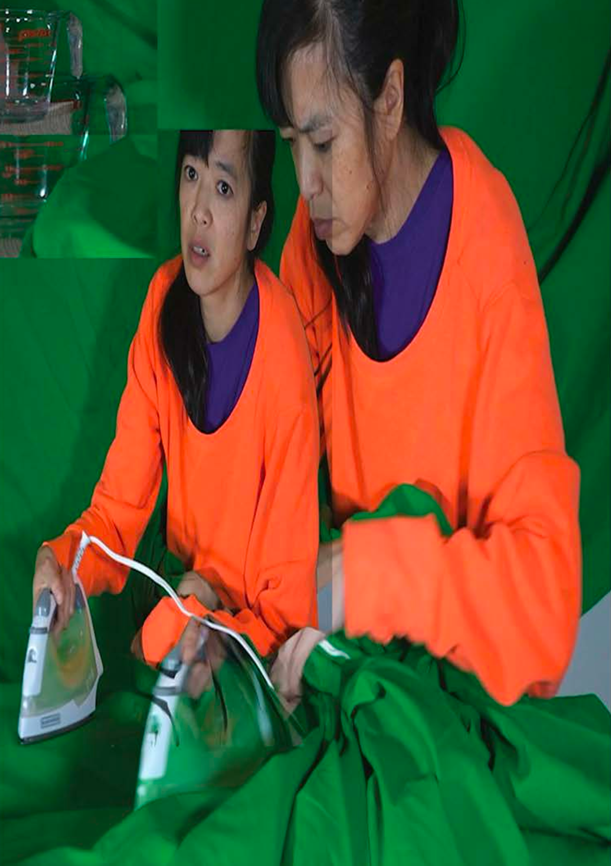 Image of a aomwn in a bright orange jumper holding an iron and looking despondent