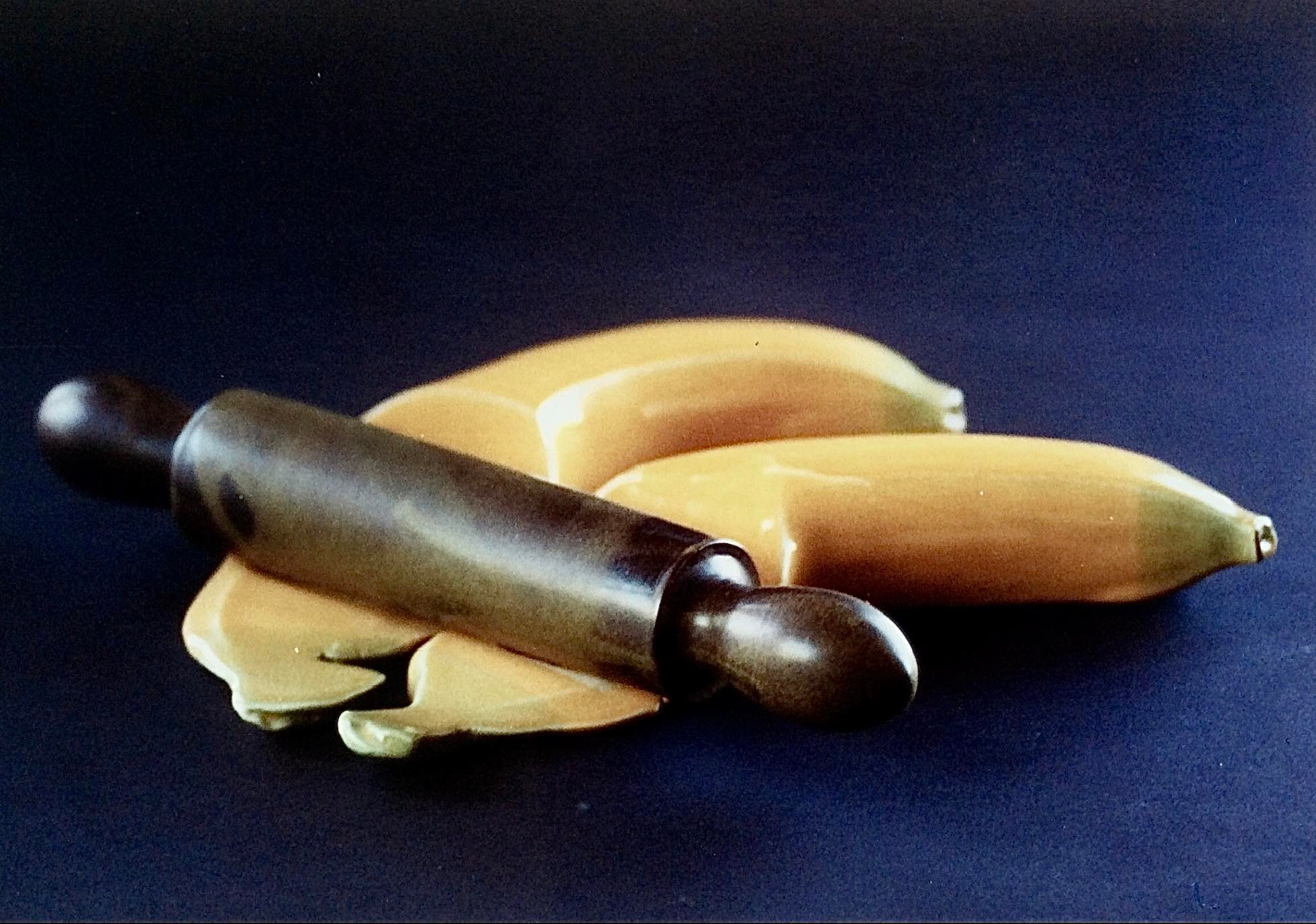 Two ceramic bananas partially flattened by a rolling pin