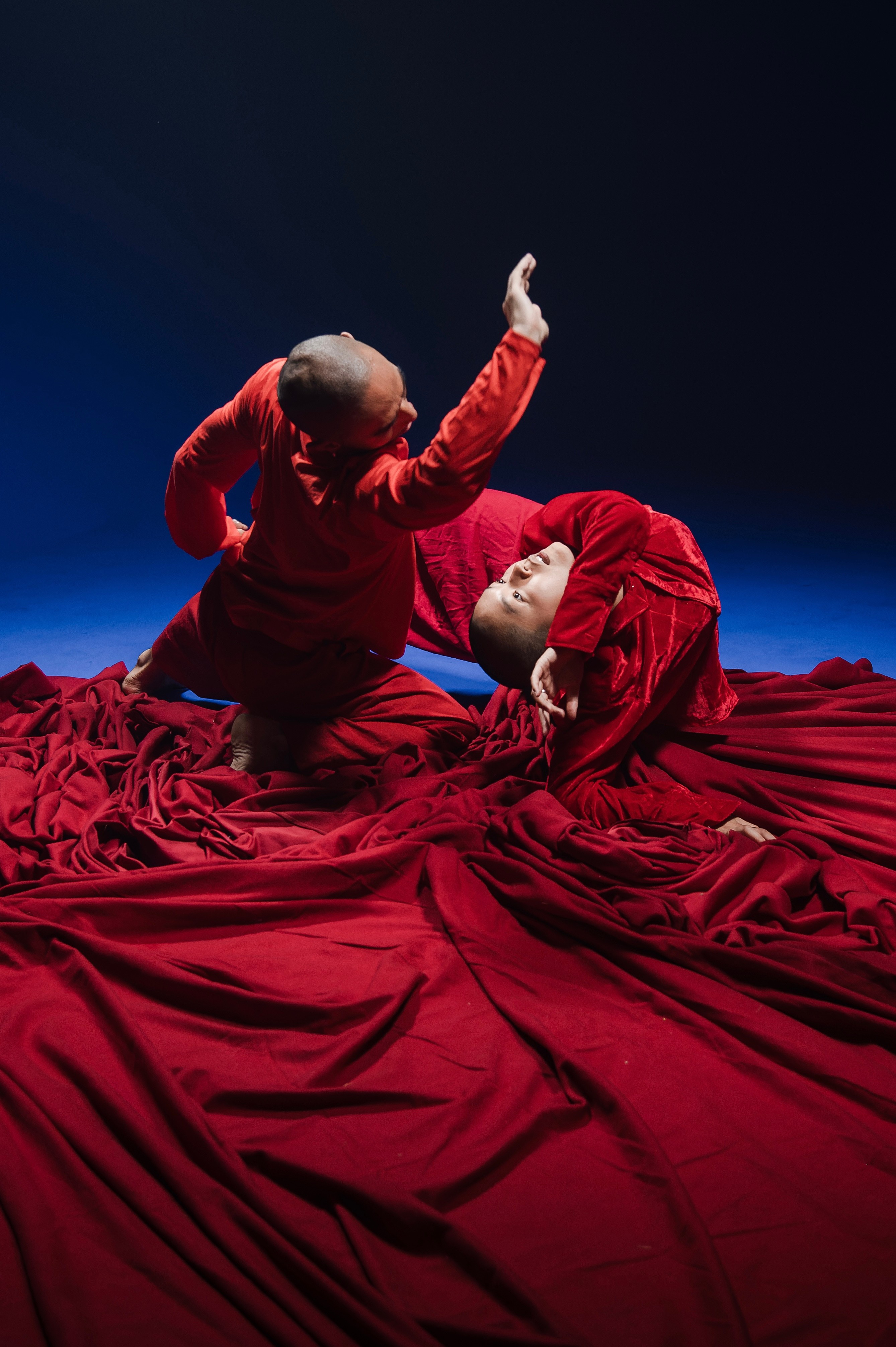 Two dancers in a sea of red cloth.