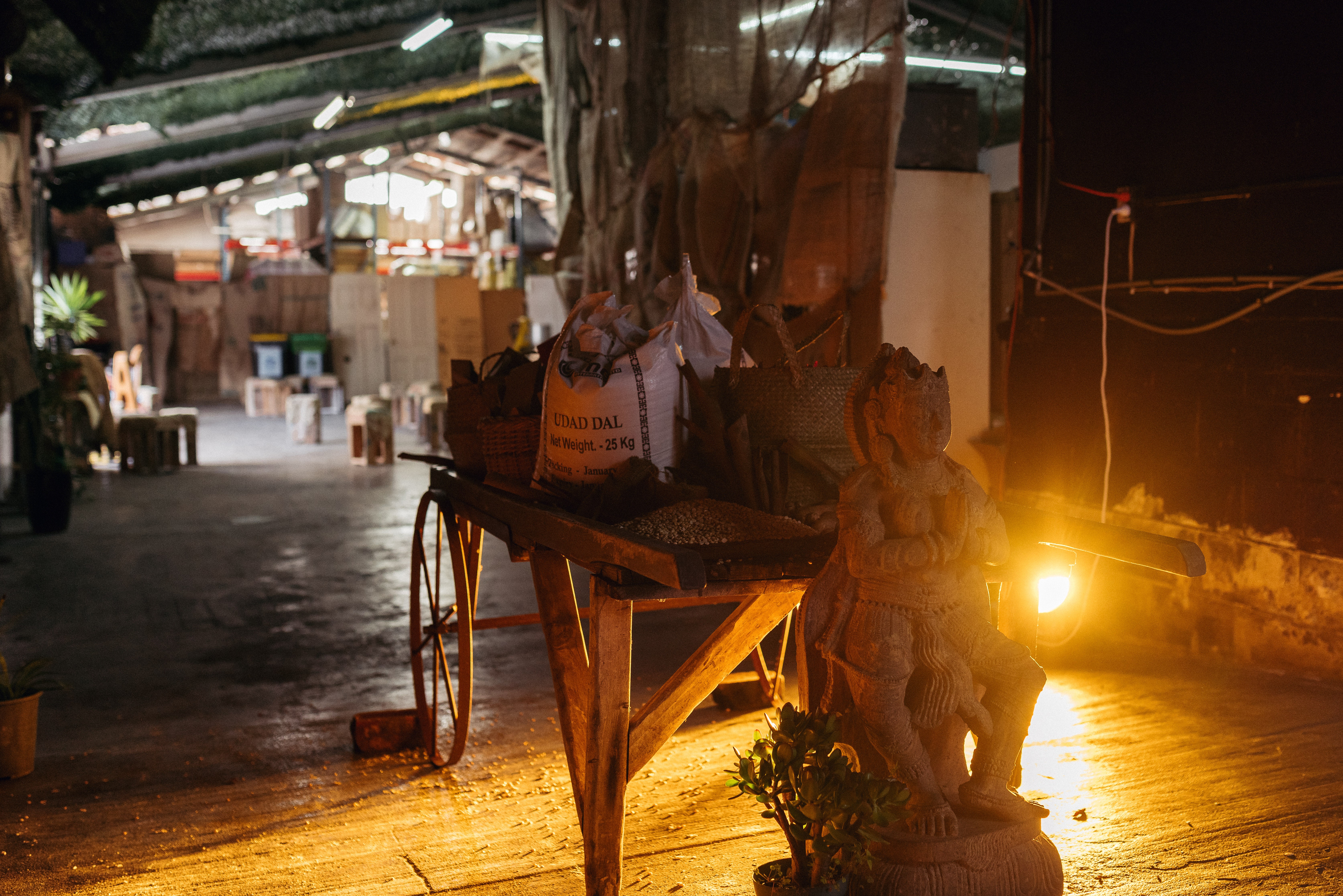 A stand with a bag of udad dal on it with a statue of a deity in front of it