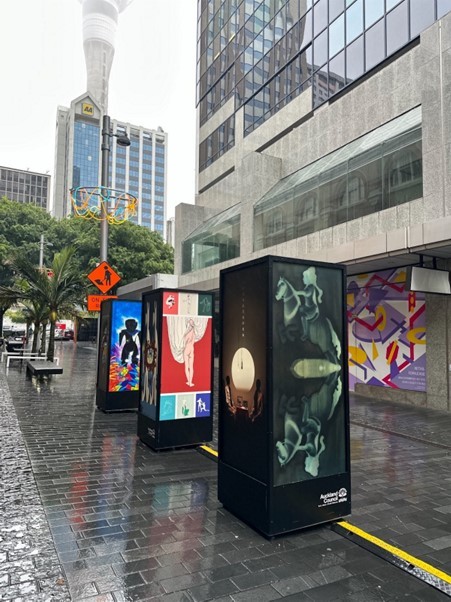 A group of billboards on a sidewalk